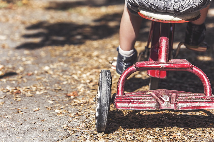 Child Riding Vintage Red Tricycle Outdoors