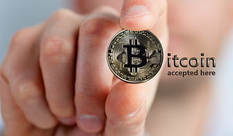 Hand holding physical Bitcoin coin with accepted here text