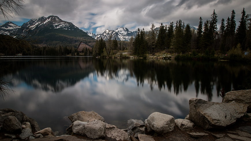 Serene Lake Reflection with Snowy Mountains and Forest