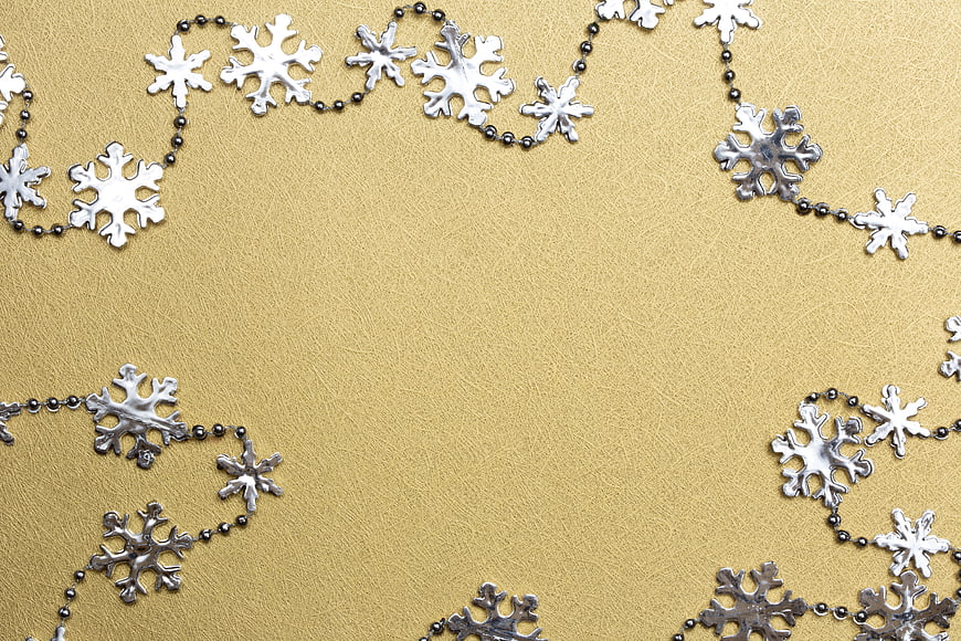Silver snowflake garland on textured gold background