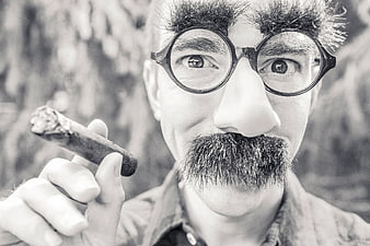 Man in Charlie Chaplin Costume Holding Cigar