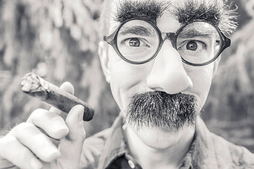 Man in Charlie Chaplin Costume Holding Cigar