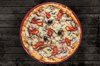 Top view of homemade pizza with ham, mushrooms, and peppers