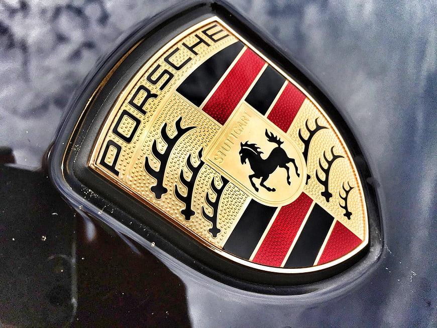 Close-up of a Porsche emblem on a dark car surface