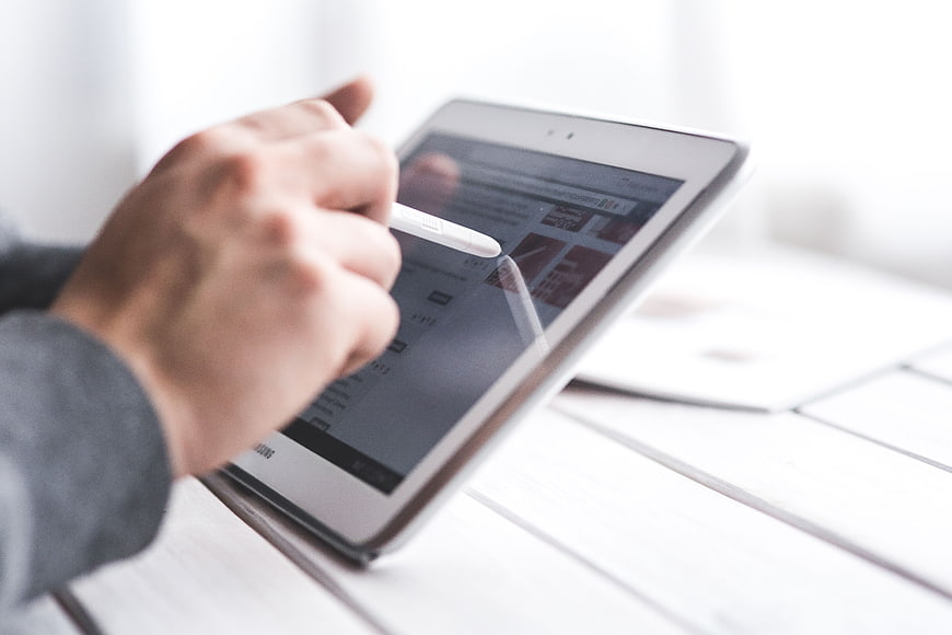 Hand using stylus on digital tablet screen