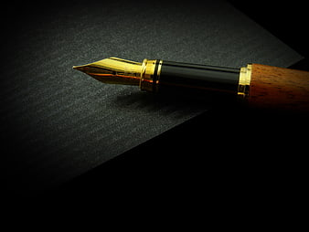 Luxury fountain pen with gold nib on dark textured background