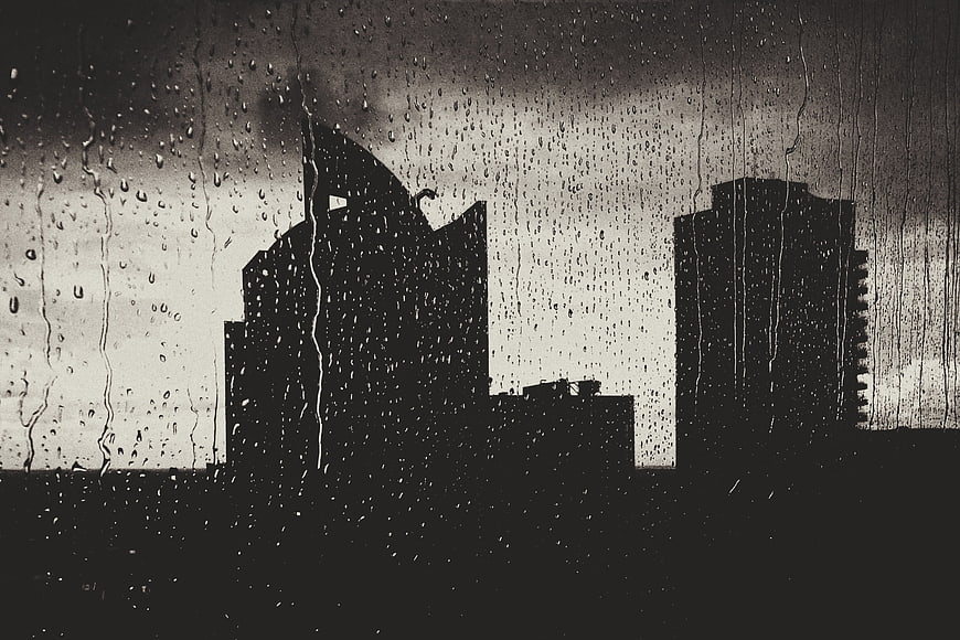 Raindrops on Window with City Skyline Silhouette