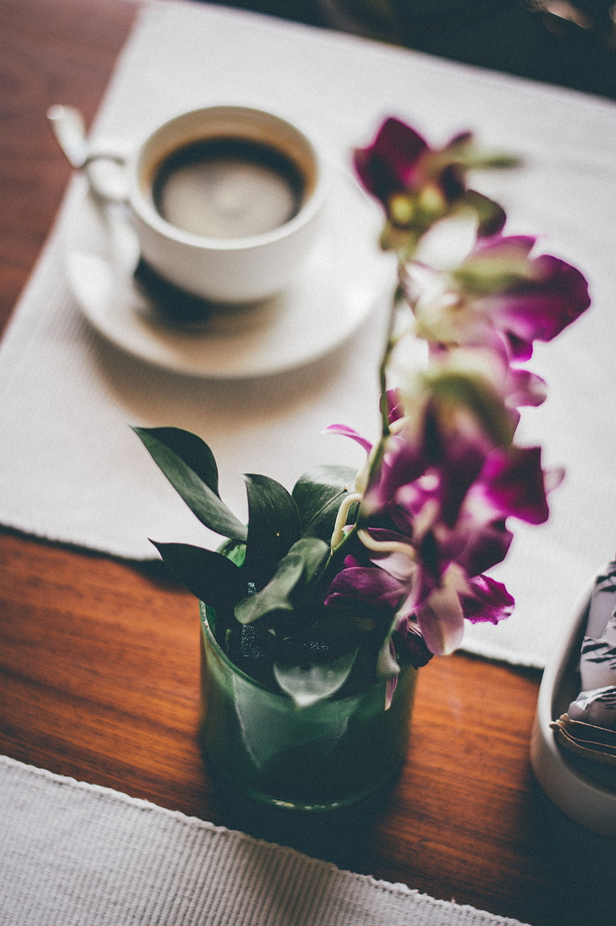 Purple Orchid and Coffee Cup on Wooden Table