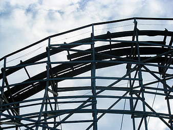 Low Angle View of Wooden Rollercoaster Tracks Against Cloudy Sky