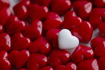 White Heart Candy Among Red Hearts Close Up