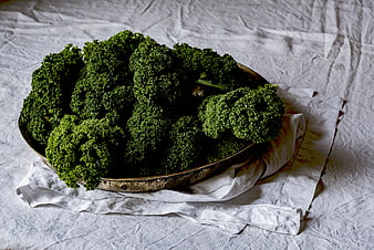 Fresh curly kale in a rustic metal bowl on linen