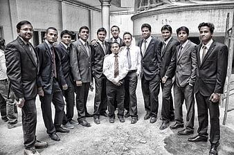 Group of young men in suits standing outdoors