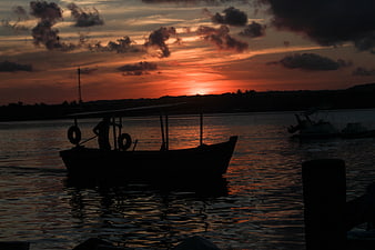 Silhouette of Fishing Boat on River at Sunset