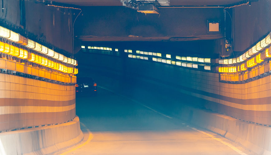 Motion Blur Car Driving Through Illuminated City Tunnel