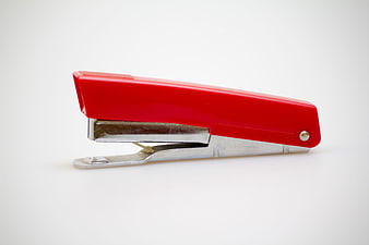 Red stapler on white background