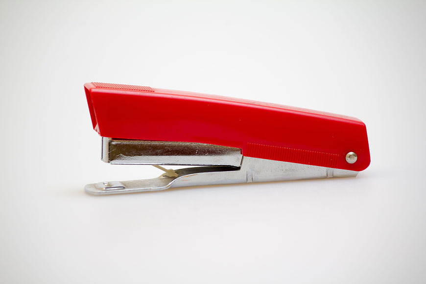Red stapler on white background