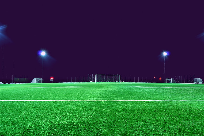 Empty soccer field at night with floodlights