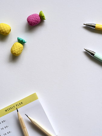 Minimalist desk flat lay with colorful clay fruit and weekly planner