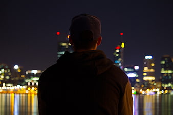Silhouette of Man Looking at City Skyline at Night