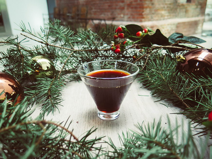 Festive Dark Cocktail in Glass with Christmas Decorations