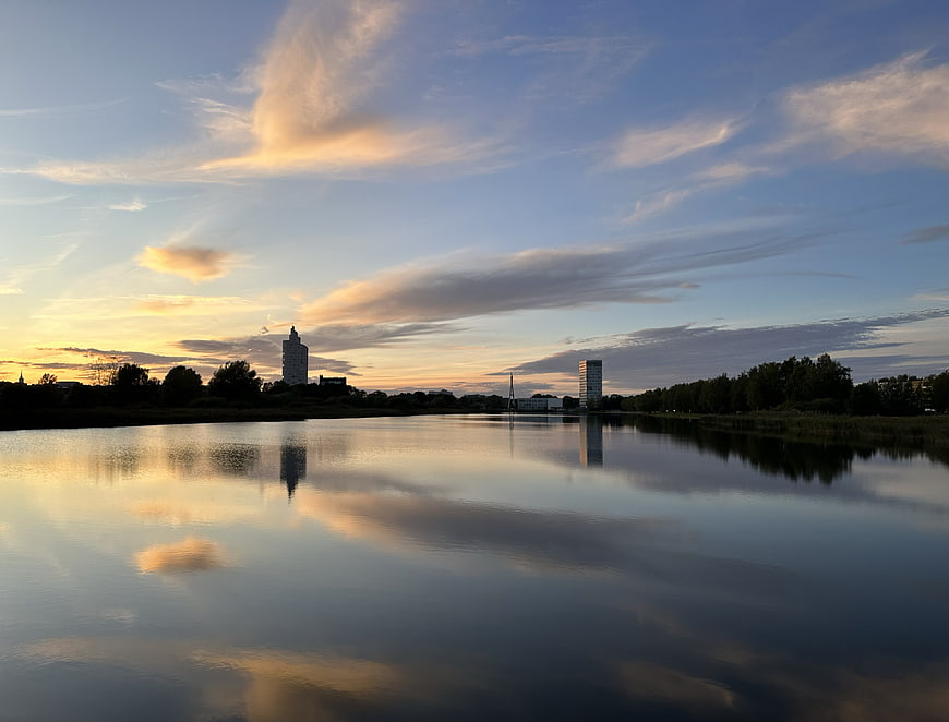 Serene River Sunset with City Skyline Reflection