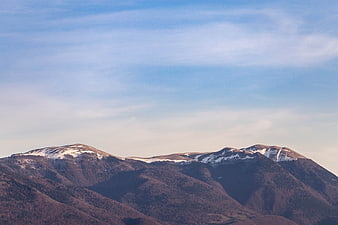 Snow-capped mountain peaks under a vast blue sky