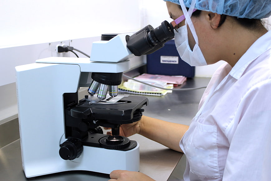 Female Scientist Using Microscope in Laboratory