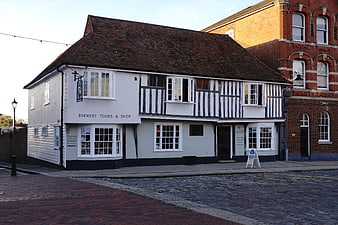 Historic Tudor-style brewery building on cobblestone street