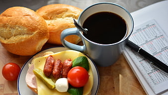 Hearty breakfast with coffee, bread, and open sandwich on wooden table