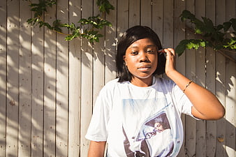 Young Black Woman Portrait in Sunlight Against Wooden Fence