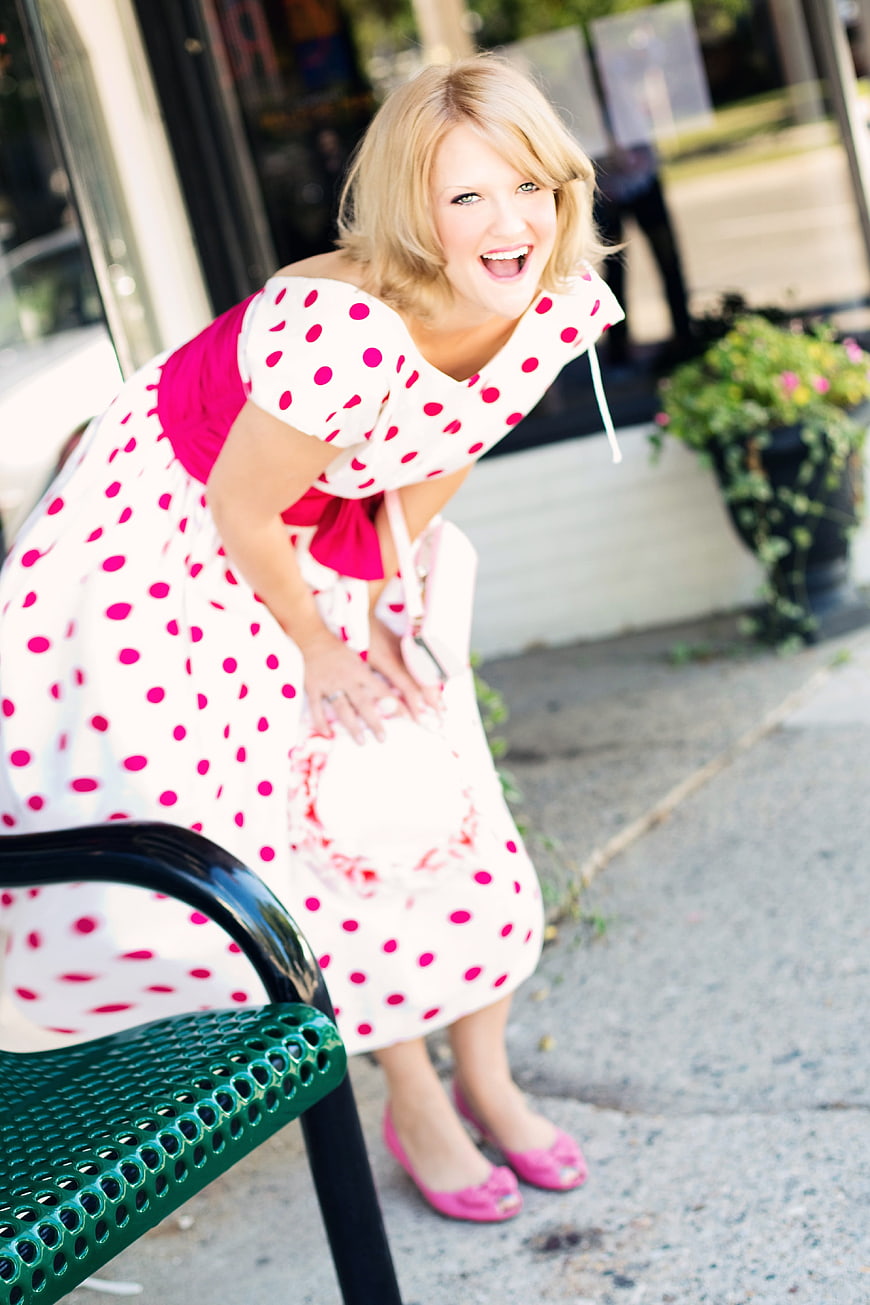 Laughing blonde woman in pink polka dot vintage dress