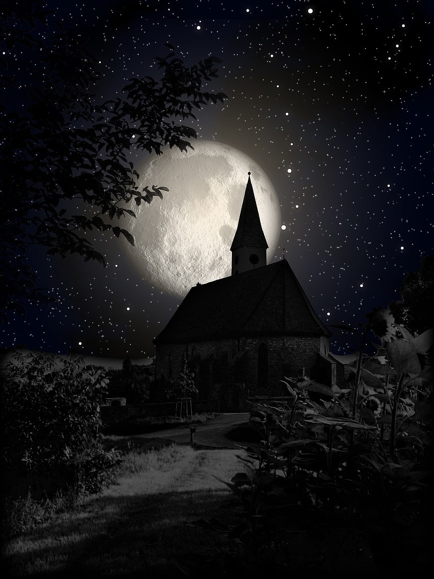 Silhouette of Gothic Church Tower Against Giant Full Moon and Starry Night Sky