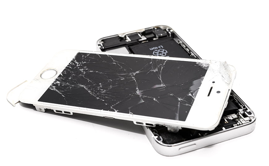 Broken white smartphone with cracked screen on white background