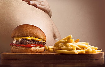 Cheeseburger and fries in front of overweight belly