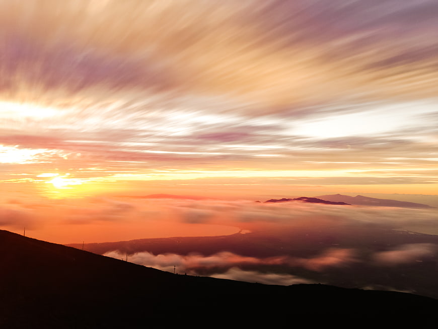 Dramatic Sunset Over Mountain Ridge with Sea of Clouds