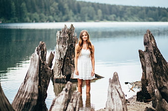 Woman in White Dress Standing in Lake Among Dead Trees