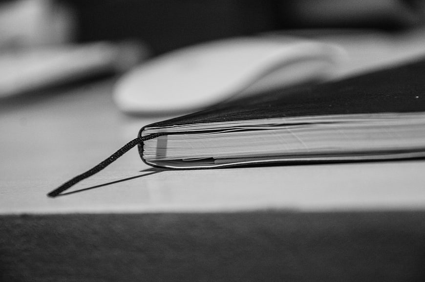 Close-up of a notebook on a desk in black and white