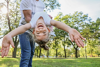 Happy Father Holding Upside Down Daughter in Park
