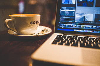 Costa Coffee Cup and Laptop with Video Editing Software