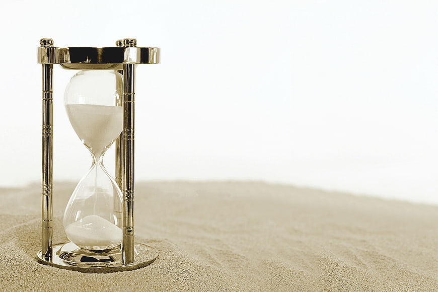 Gold Hourglass on Sand with White Background