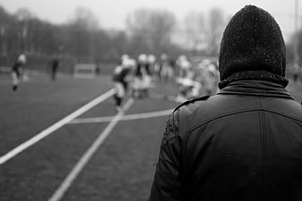 Spectator watching football game in black and white