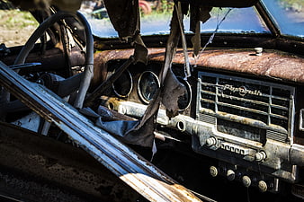Rusty vintage Plymouth car interior with torn upholstery