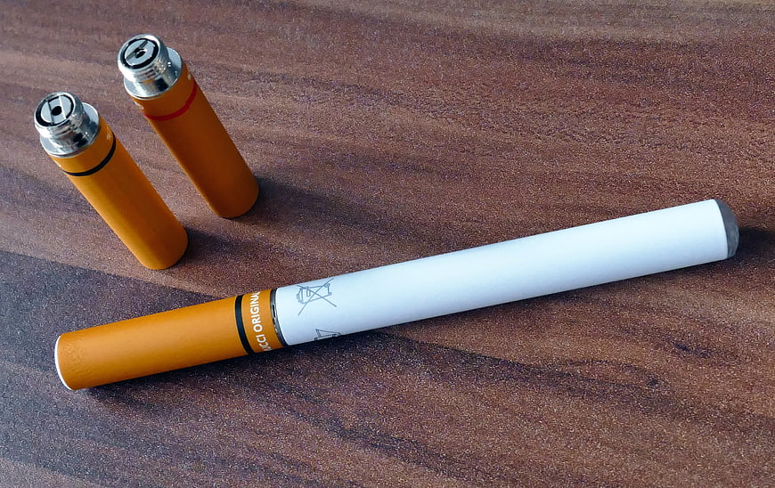 Vaping Device and Cartridges on Wooden Surface
