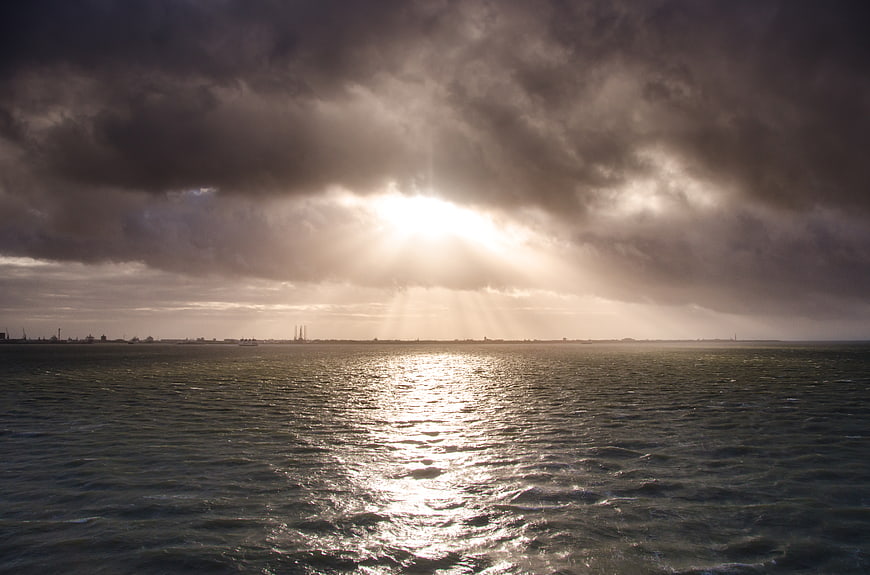 Dramatic Sun Rays Breaking Through Storm Clouds Over Ocean