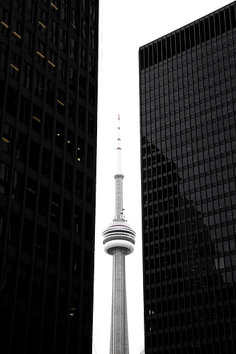CN Tower Framed Between Dark Skyscrapers in Toronto