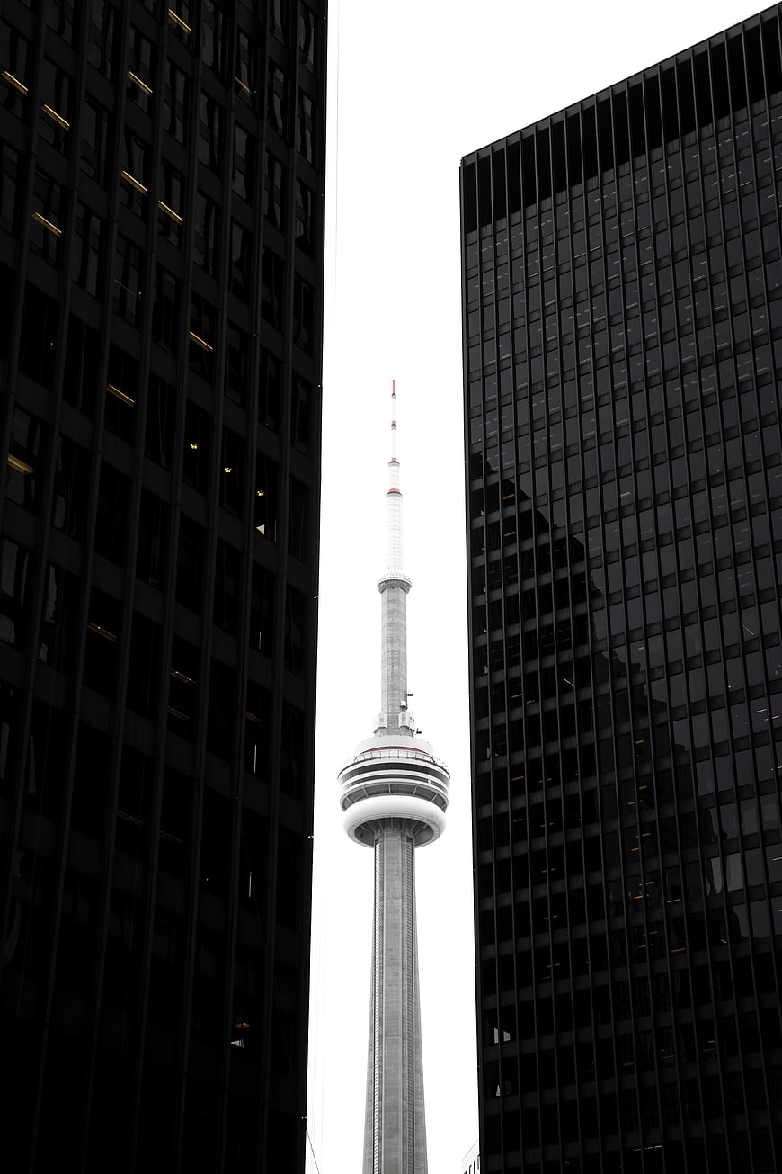 CN Tower Framed Between Dark Skyscrapers in Toronto