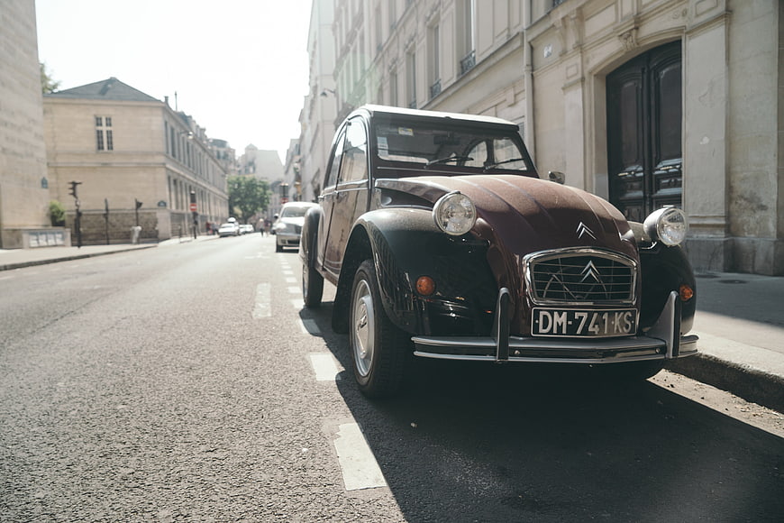 Vintage Citroën 2CV parked on a sunny Parisian street