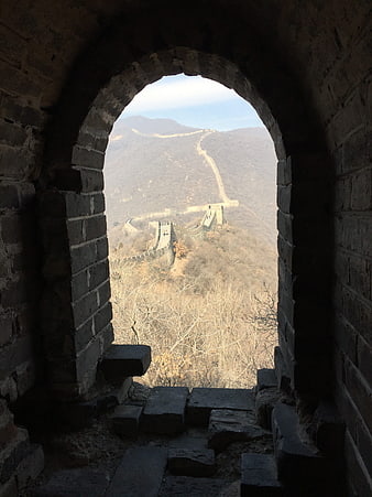 View of Great Wall of China through ancient stone archway