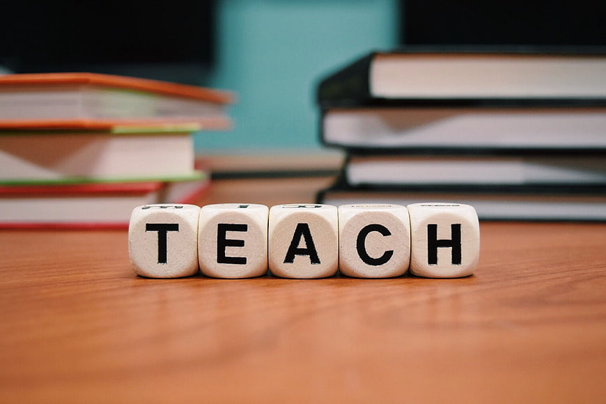 Teach Word on Wooden Dice with Books Background
