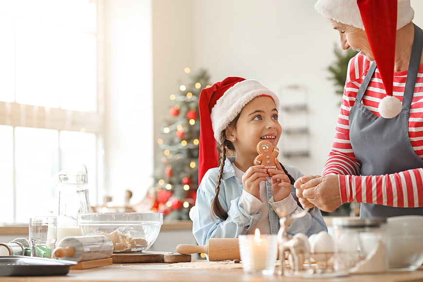 Grandmother and granddaughter baking gingerbread cookies at Christmas